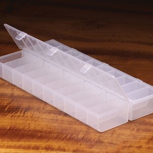 K&ouml;nnte beinhalten: Eine transparente Plastik-Aufbewahrungsbox mit einem Scharnierdeckel und mehreren F&auml;chern. Die Box ist ge&ouml;ffnet und der Deckel ist hochgeklappt.