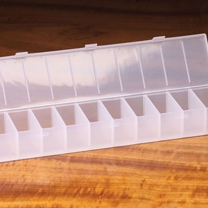 K&ouml;nnte beinhalten: Eine transparente Plastik-Aufbewahrungsbox mit 10 F&auml;chern. Die Box ist ge&ouml;ffnet und der Deckel liegt obenauf.