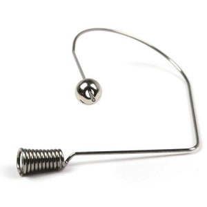 May include: A silver metal wire spring with a round ball at the end. The spring is bent into a U-shape.