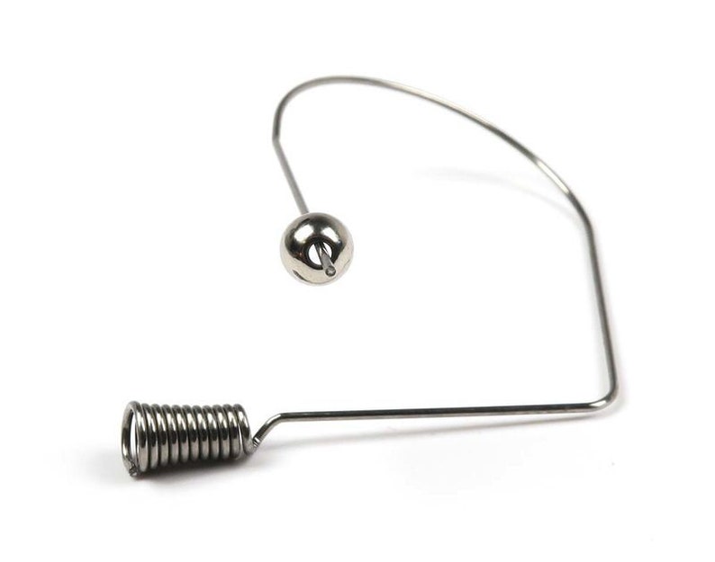 May include: A silver metal wire spring with a round ball at the end. The spring is bent into a U-shape.