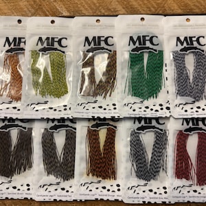 May include: Ten packages of MFC brand Centipede Legs in various colors, including speckled yellow, olive, brown, green, and white. Each package is sealed in clear plastic with black and white polka dot accents.