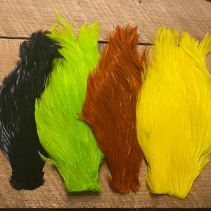 May include: Four pheasant tail feathers in different colors: black, lime green, orange, and yellow.