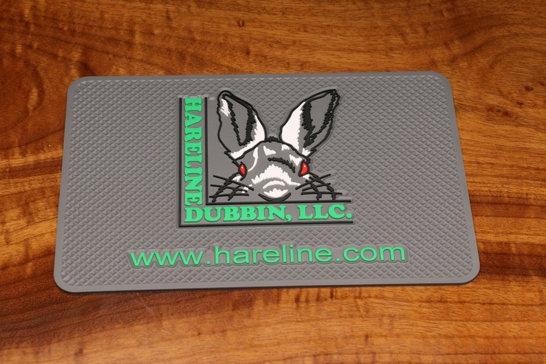 May include: Gray rubber mouse pad with a green and white logo featuring a rabbit's face and the text "HARELINE DUBBIN, LLC. www.hareline.com"