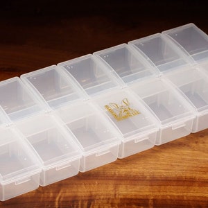 K&ouml;nnte beinhalten: Eine transparente Aufbewahrungsbox aus Kunststoff mit 12 F&auml;chern. Die Box hat ein abgerundetes Design und ist ideal zum Organisieren kleiner Gegenst&auml;nde.