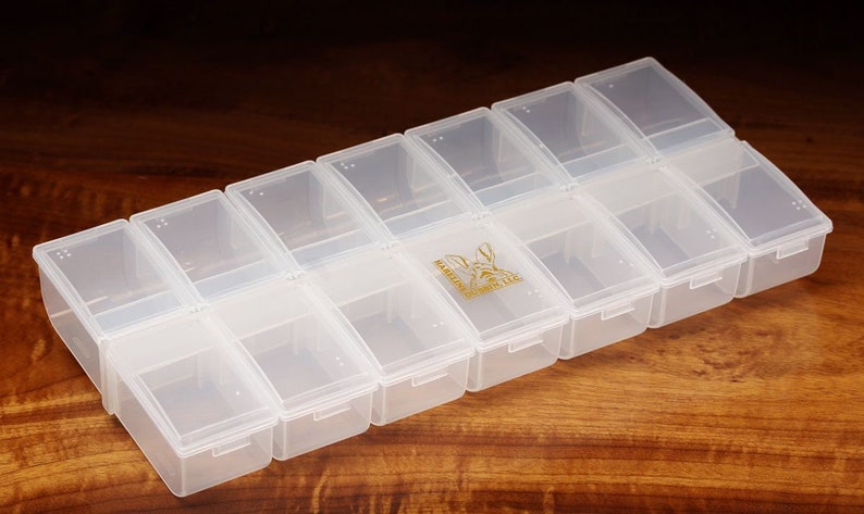 K&ouml;nnte beinhalten: Eine transparente Aufbewahrungsbox aus Kunststoff mit 12 F&auml;chern. Die Box hat ein abgerundetes Design und ist ideal zum Organisieren kleiner Gegenst&auml;nde.