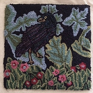 Peut inclure: Un tapis carré fait à la main représentant un corbeau noir entouré de feuilles et de fleurs. Le corbeau est détaillé avec des nuances de violet et de marron, sur des éléments floraux verts, bleus et roses sur fond noir. Le tapis est probablement en laine.