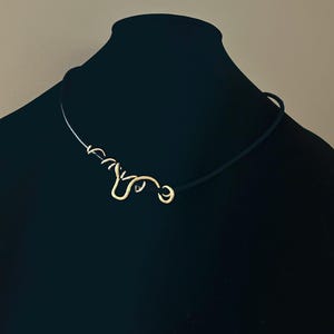 Goud-zwarte sculpturale halsketting. Handgemaakte geometrische hanger, met draad omwikkeld sierlijk sieraad, optie voor oorbellen.
