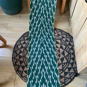 May include: Green and white ikat fabric with a yellow border. The fabric has a repeating pattern of white teardrop shapes on a green background.