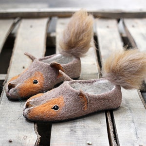 May include: A pair of brown and orange felt slippers shaped like squirrels with fluffy tails.