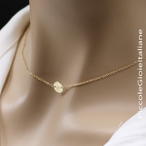 Może przedstawiać: Złoty naszyjnik z łańcuszkiem i małym okrągłym wisiorkiem z wygrawerowaną literą "P".