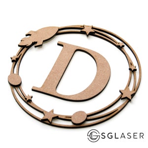 Op de afbeelding: Een houten letter D met een ruimtethema. De letter is omringd door een cirkel van sterren, planeten en een raket.