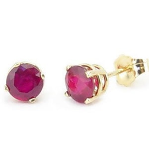 May include: A pair of gold stud earrings with round red ruby gemstones.