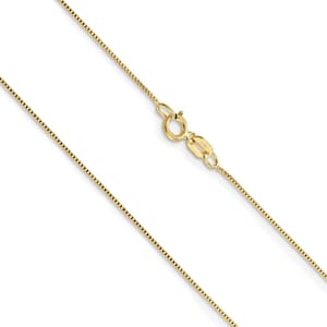 May include: A gold chain necklace with a box clasp. The chain is thin and delicate.