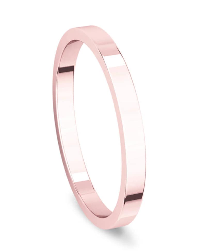 Op de afbeelding: Een eenvoudige, gepolijste ros&eacute;gouden trouwring. De ring is plat en heeft een gladde afwerking.