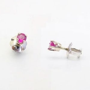May include: A pair of silver stud earrings with a small, round, pink gemstone in the center of each earring.