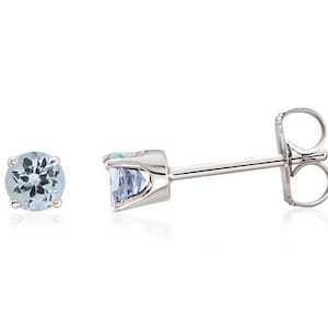 May include: A pair of silver stud earrings with a light blue gemstone in each earring.