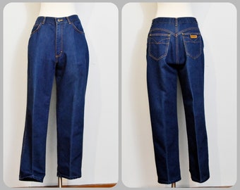 May include: A pair of dark blue denim jeans with a straight leg fit. The jeans have a high waist and are made of a soft, comfortable fabric.