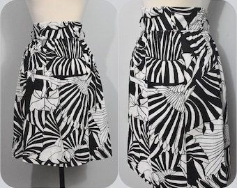 May include: A black and white skirt with a geometric pattern. The skirt has a high waist and a flared silhouette.