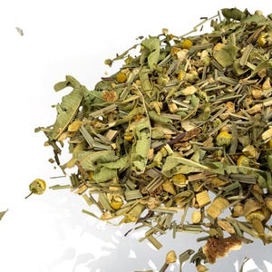 May include: A close-up of a pile of dried herbal tea leaves and flowers. The tea blend includes green leaves, yellow chamomile flowers, and various other dried herbs. The image is set against a white background.