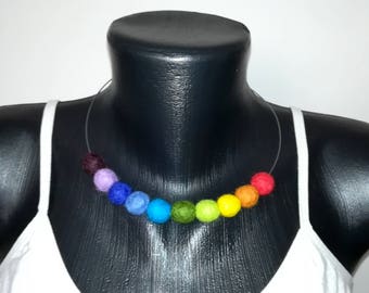 Puede incluir: Un collar de cuentas de fieltro de colores del arcoíris en un maniquí. Las cuentas están enhebradas en un alambre transparente y están en el orden de rojo, naranja, amarillo, verde, azul, añil y violeta.