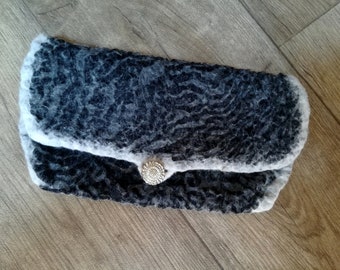 May include: A black and white felted clutch with a silver button closure.