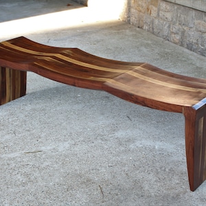 Long black walnut bench with three curves