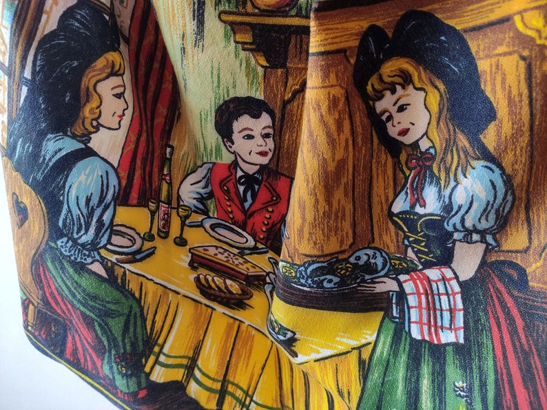Puede incluir: Un mantel vintage con una ilustraci&oacute;n colorida de tres personas sentadas en una mesa. El mantel tiene un fondo amarillo con acentos marrones, verdes y rojos. La ilustraci&oacute;n representa a una mujer con un vestido azul y verde, un hombre con un chaleco rojo y una mujer con un vestido verde y negro. El mantel tiene un borde a rayas verde y blanco.