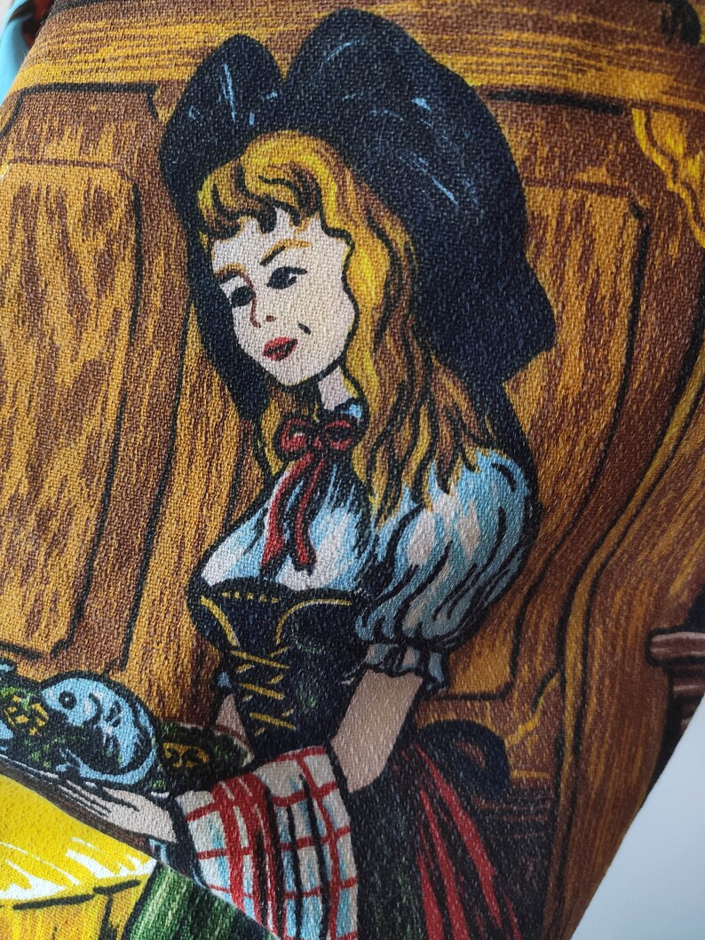 Puede incluir: Una ilustraci&oacute;n vintage de una mujer con un vestido azul y blanco con una cinta roja. Est&aacute; sosteniendo un plato con un dise&ntilde;o azul y blanco. El fondo es un panel de madera marr&oacute;n.