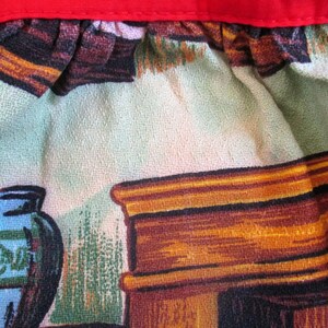 Puede incluir: Primer plano de una tela vintage con un dise&ntilde;o del suroeste. La tela presenta un jarr&oacute;n de cer&aacute;mica azul y verde, una chimenea de madera y un fondo estampado verde y marr&oacute;n.