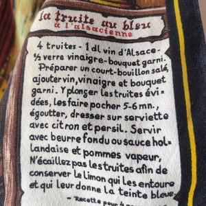 Puede incluir: Una tarjeta de receta blanca y amarilla con texto negro. La receta es para "la truite au bleu &agrave; l'alsacienne" (trucha en azul, estilo alsaciano). La receta incluye ingredientes como trucha, vino, vinagre y lim&oacute;n. Tambi&eacute;n incluye instrucciones para pochar la trucha y servirla con mantequilla, salsa o patatas.