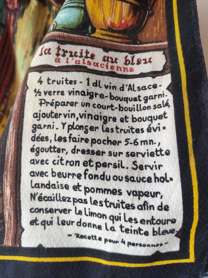 Puede incluir: Una tarjeta de receta blanca y amarilla con texto negro. La receta es para "la truite au bleu &agrave; l'alsacienne" (trucha en azul, estilo alsaciano). La receta incluye ingredientes como trucha, vino, vinagre y lim&oacute;n. Tambi&eacute;n incluye instrucciones para pochar la trucha y servirla con mantequilla, salsa o patatas.