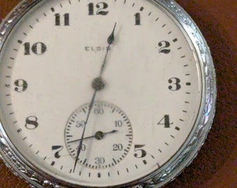 Reloj de bolsillo antiguo Elgin de 1922, con caja ornamentada, tamaño 12 y 7 rubíes, funcionando y marcando la hora.