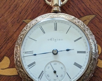 Elgin 1898, tamaño 18, movimiento de 7 joyas en caja ornamentada, funcionando y manteniendo la hora.