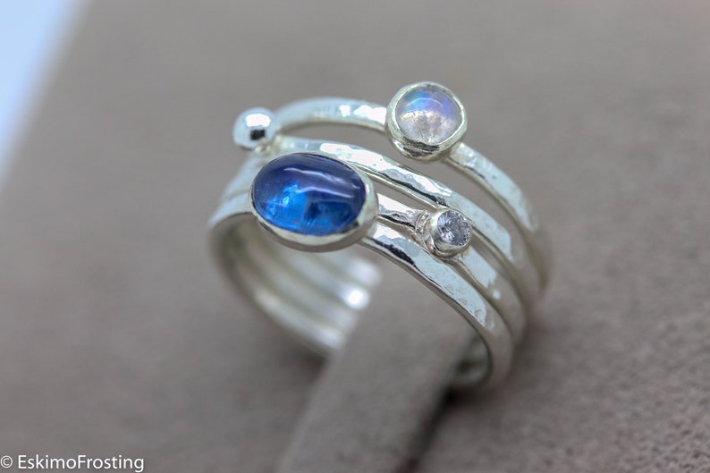 K&ouml;nnte beinhalten: Ein silberner Ring mit drei Steinen. Der gr&ouml;&szlig;te Stein ist ein blauer Oval, der mittlere Stein ist ein wei&szlig;er runder Stein und der kleinste Stein ist ein wei&szlig;er runder Stein.