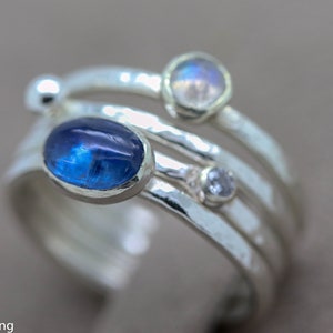 K&ouml;nnte beinhalten: Ein Silberring mit drei Steinen. Der gr&ouml;&szlig;te Stein ist ein blauer Oval, die anderen beiden sind kleiner und rund. Der Ring ist aus geh&auml;mmertem Silber gefertigt.