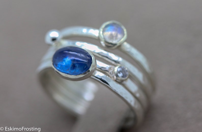 K&ouml;nnte beinhalten: Ein Silberring mit drei Steinen. Der gr&ouml;&szlig;te Stein ist ein blauer Oval, die anderen beiden sind kleiner und rund. Der Ring ist aus geh&auml;mmertem Silber gefertigt.