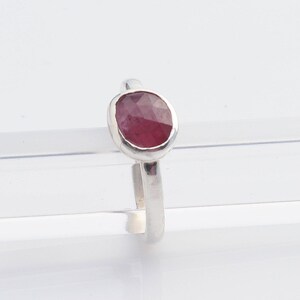 May include: A silver ring with a pink oval gemstone set in a bezel setting.
