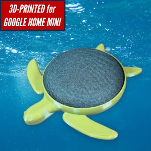 May include: A 3D-printed green turtle shell case for a Google Home Mini smart speaker. The speaker is visible inside the shell, and the case is floating in blue water.