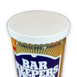 May include: A white plastic container with a gold and blue label that reads "Bar Keepers Friend". The label also says "Stainless Steel, Porcelain, Ceramic".