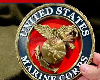 May include: A 3D EGA with USMC seal. The emblem features a gold-colored eagle, globe, and anchor design set against a red background. The words "UNITED STATES MARINE CORPS" are displayed in white lettering around the emblem's border.