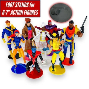May include: A collection of seven X-Men action figures including Cyclops, Gambit, Jean Grey, Storm, Magneto, Wolverine, Beast, and Bishop, each on a circular plastic base. Text at the top reads: FOOT STANDS for 6-7" ACTION FIGURES.