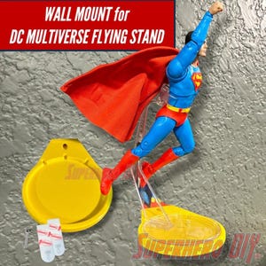 May include: Yellow wall mount for a DC Multiverse flying stand. The mount is a circular disc with a screw hole in the center. The stand is made of clear plastic and has a yellow base. The stand is designed to hold a Superman action figure.