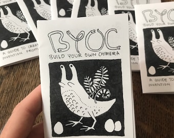 May include: A stack of small, white booklets with black ink illustrations and text. The cover of the booklet reads "BYOC Build Your Own Chimera" with a drawing of a creature. The text "A Guide to Creature Invention From JAM" is also visible.