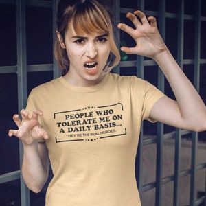 May include: A yellow t-shirt with a black graphic that reads "People who tolerate me on a daily basis... They're the real heroes."