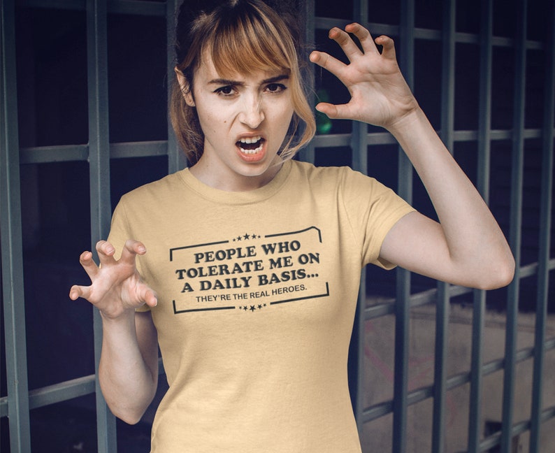 May include: A yellow t-shirt with a black graphic that reads "People who tolerate me on a daily basis... They're the real heroes."