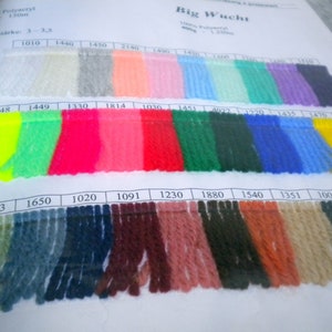 Könnte beinhalten: Eine Garnfarbkarte mit einer Vielzahl von Farben, darunter Weiß, Grau, Rosa, Rot, Grün, Blau, Gelb und Braun. Die Karte ist mit "Big Wucht" beschriftet und enthält Nummern für jede Farbe.