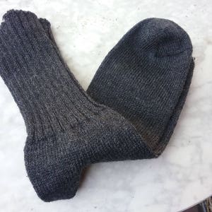 May include: A pair of gray wool socks. The socks are folded in half and the top of the socks are visible.