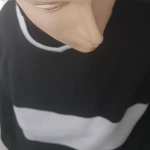 May include: A black and white striped jumper with a white trim around the neckline.