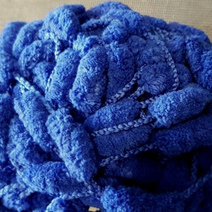 May include: A ball of blue fuzzy yarn with pom-poms. The yarn is soft and fluffy, and the pom-poms are a fun addition.