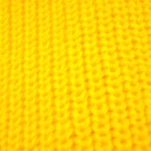 May include: Close-up of a bright yellow knitted fabric with a textured pattern.